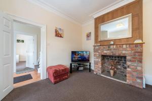 a living room with a fireplace and a tv at Thy Grace 3 Bedroom 2 Shower Room Central Location in Hull