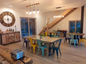 comedor con mesas y sillas y reloj en Chambres d`hôtes Domaine des Haies en Dol-de-Bretagne