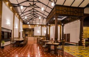 a restaurant with tables and chairs in a room at River Mist Resort in Mudigere