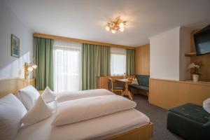 a hotel room with two beds and a table at Appartement Hotel Garni Matthäuserhof in Gerlos