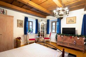 a living room with a television and a chandelier at Magdolna Vendégház Magánszálláshely in Écs