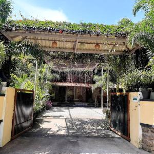 an entrance to a garden with a gate with plants at Anna Homestay in Munnar