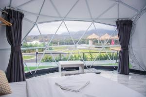 a tent with a view of a golf course at ไร่บำรุงผล Raibumrungphol in Mae Wang