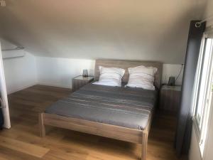 een bed met twee kussens in een kamer bij duplex BOUGUAINVILLIER 2 in Saint-Denis