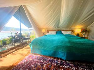 TanakpurにあるLUSHY DAYS BOOM CAMPのベッドルーム1室(ベッド1台付)が備わります。