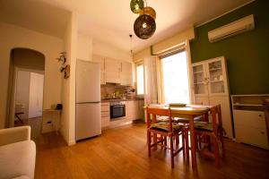 una cucina con tavolo e frigorifero bianco di GetTheKey Duse Apartment a Bologna