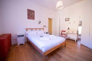 - une chambre avec un grand lit et un bureau dans l'établissement GetTheKey Duse Apartment, à Bologne