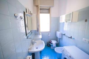 un bagno blu e bianco con lavandino e servizi igienici di GetTheKey Duse Apartment a Bologna