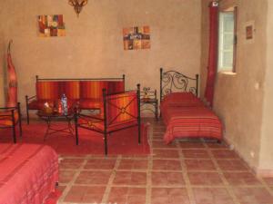 een slaapkamer met 2 bedden en een tafel in een kamer bij Riad Ain Khadra in Taroudant