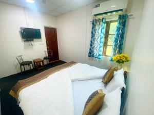 TanakpurにあるLUSHY DAYS BOOM CAMPのベッドルーム1室(白いシーツが備わるベッド2台、窓付)