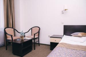 a hotel room with a bed and a table and chair at Flagman in Omsk