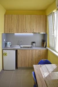 a kitchen with wooden cabinets and a white refrigerator at Starlight Studios in Burgas City