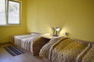 a bedroom with two beds and a desk with a lamp at Starlight Studios in Burgas City
