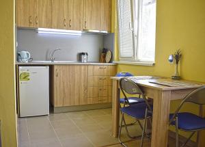 a kitchen with a refrigerator and a table and chairs at Starlight Studios in Burgas City