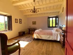 ein Schlafzimmer mit einem Bett und einem Stuhl darin in der Unterkunft Podere Terreno alla via della volpaia in Radda in Chianti