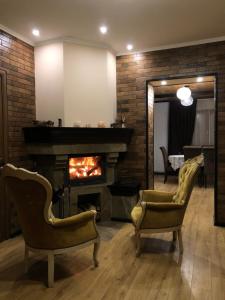 a living room with two chairs and a fireplace at Mountain Residence in Tukhlya