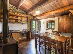 a kitchen with a wooden table and a stove at Villa Vallorsaia con piscina privata in Sansepolcro