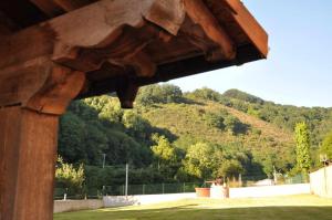 un edificio de madera con una montaña en el fondo en Casa rural Barbenea, en Oronoz-Mugaire