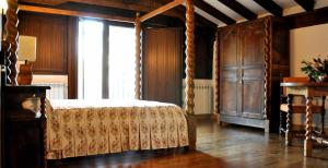 a bedroom with a canopy bed and a large window at Casa rural Barbenea in Oronoz-Mugaire