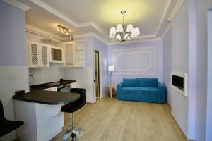 salon z niebieską kanapą i stołem w obiekcie Romantic Lux Vivaldi Suite Svobode avenue 39 w Lwowie