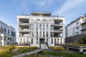 ein weißes Gebäude mit einer Treppe davor in der Unterkunft Villa Claire meerZEIT in Ostseebad Sellin