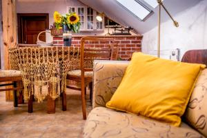 a living room with a table and a yellow pillow on a couch at Mazurska Arkadia in Stare Juchy