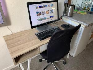 a desk with a computer monitor and a black chair at Central & Cosy Studio + Free Bikes & Netflix in Copenhagen
