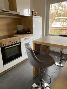 a kitchen with a chair and a table and a stove at Apartment Kleine Kremper in Glückstadt