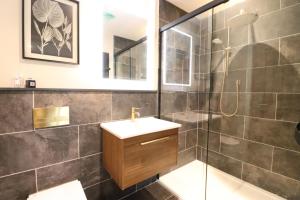 a bathroom with a sink and a glass shower at Tarn End Cottage 8, Talkin Tarn, Brampton in Carlisle