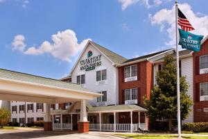 einen vorderen Blick auf ein Hotel mit einer Flagge in der Unterkunft Country Inn & Suites by Radisson, Elgin, IL in Elgin