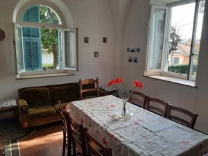 una sala de estar con una mesa con flores rojas. en Casa Gazzano, en Imperia