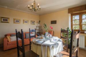 ein Esszimmer mit einem Tisch und einem Kronleuchter in der Unterkunft Bellavista in Cortona