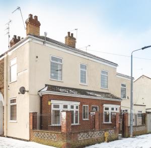 a brick house with a fence on a snowy street at Thy Grace 3 Bedroom 2 Shower Room Central Location- Newland Ave in Hull