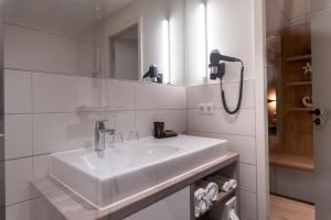 a white bathroom with a sink and a mirror at Villa Prinzhorn in Diepholz