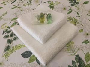 a white towel with three bottles on it on a bed at Pilkingtons Guest House Accrington in Accrington