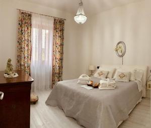 een witte slaapkamer met een bed met handdoeken erop bij AGRITURISMO BOSCO LONGHINO in Santa Maria della Versa