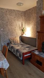 um quarto com uma cama e uma mesa com um candeeiro em Levendulás Vendégház em Zalaegerszeg