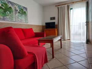 a living room with a red couch and a table at Apartamentos Acuario Sol in Puerto del Carmen