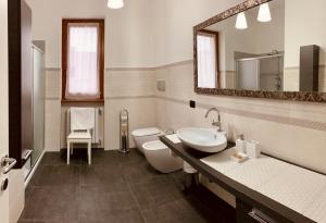 a bathroom with a sink and a toilet and a mirror at AGRITURISMO BOSCO LONGHINO in Santa Maria della Versa