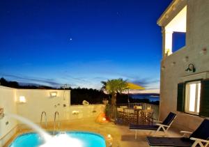 a villa with a swimming pool at night at Villa Angelina in Mirce
