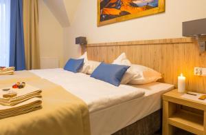 a hotel room with two beds and a candle on a table at Grand Tatry in Białka Tatrzańska