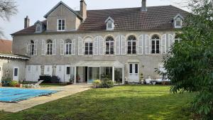 a large house with a swimming pool in front of it at La Levriere d'Arc les Gray Chambre D'hotes in Arc