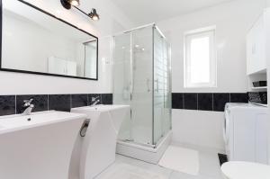 ein weißes Badezimmer mit Waschbecken und Dusche in der Unterkunft House Andrijana in Novi Vinodolski + 23 Fotos