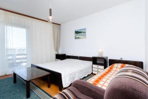 ein Schlafzimmer mit einem Bett, einer Couch und einem Tisch in der Unterkunft House Andrijana in Novi Vinodolski