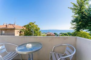 a blue table and two chairs on a balcony at Apartments Andrijana in Rijeka