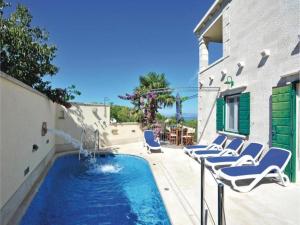 a swimming pool with lounge chairs next to a building at Villa Angelina Supetar in Mirce