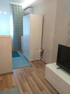 uma sala de estar com uma televisão e uma sala com um armário em Elizabeth Apartman 2 em Hévíz