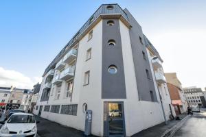 a white building with a clock tower on the side of it at Appartement charmant à Rouen, 40 m², balcon et vue sur la ville. in Rouen