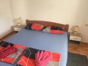 a bedroom with a bed with two pink gloves on it at Apartments ADRIANA in Žuljana