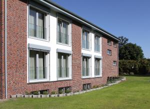 ein Backsteingebäude mit seitlichen Fenstern in der Unterkunft Hotel Ratsstuben in Rehden